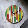 Vidám és színes geometrikus mintákkal díszített üveg falióra, mely frissességet és életteliséget sugároz